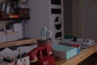Red telephone on a desk full of stationary