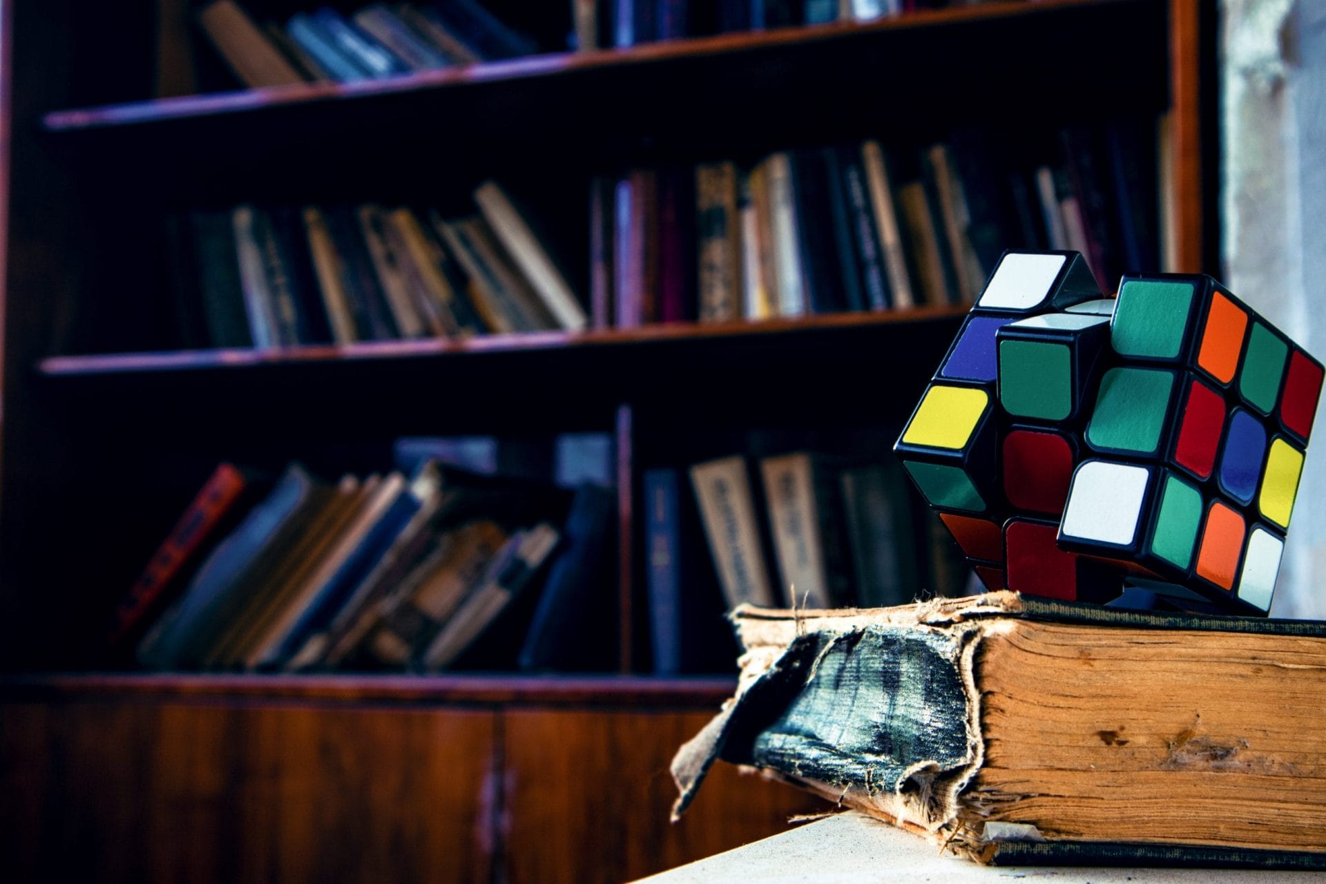 Rubix cube puzzle on top of old book